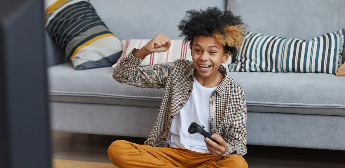 boy smiling and playing videogames